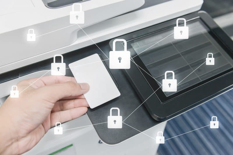 AdobeStock 224978046 scaled hp secure printing - image shows lock icons around an office printer with a hand using an ID card to secure print job